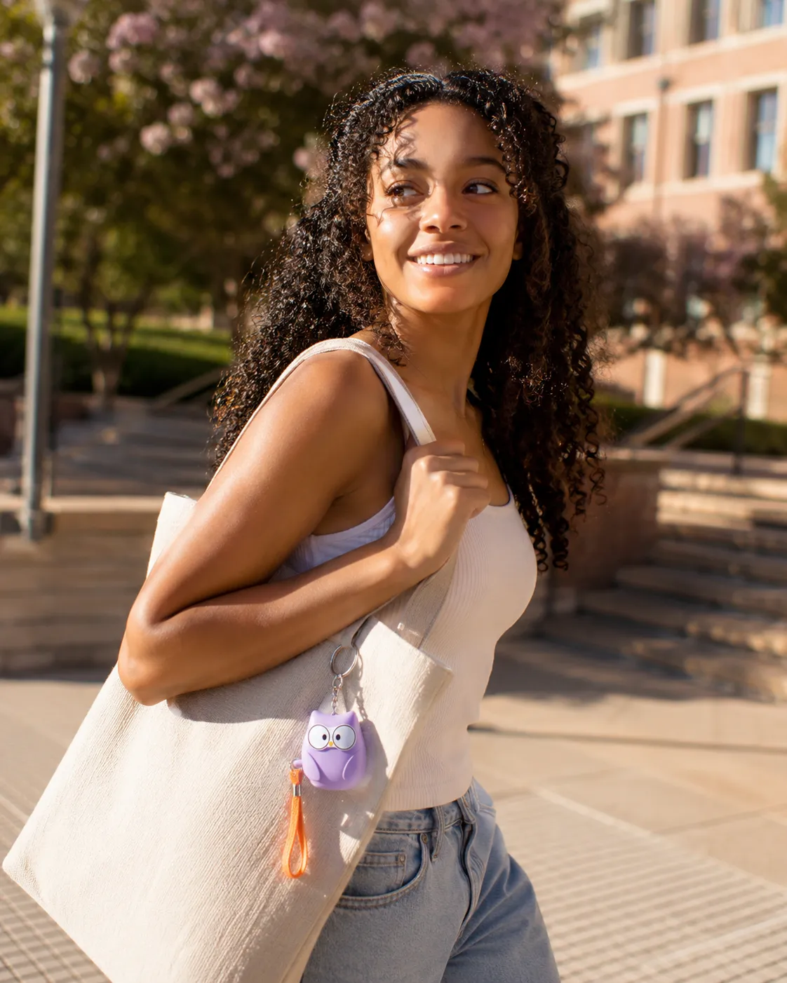 A woman out at night with her keychain alarm clipped to her bag